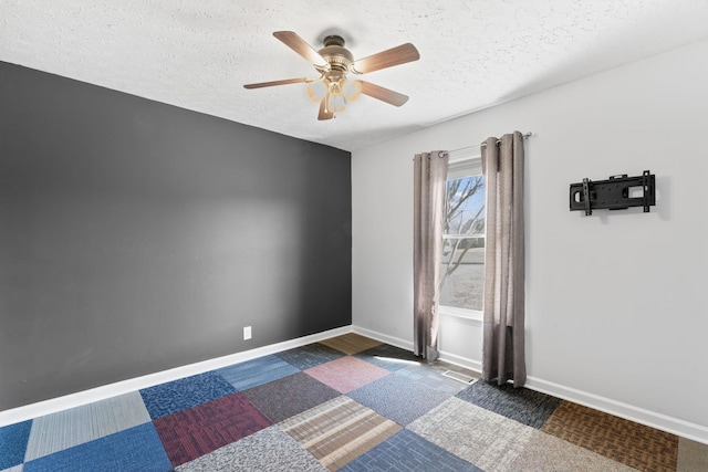 unfurnished room featuring baseboards, a textured ceiling, and ceiling fan