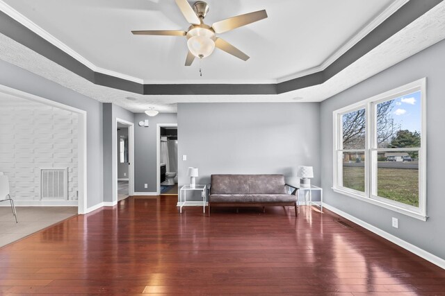 unfurnished room featuring visible vents, baseboards, a raised ceiling, a ceiling fan, and wood-type flooring