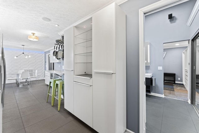 hallway with crown molding, baseboards, and a textured ceiling