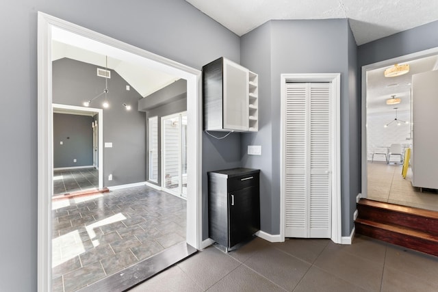 kitchen with visible vents, baseboards, open shelves, freestanding refrigerator, and vaulted ceiling