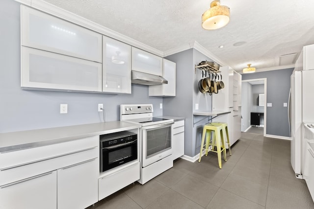 kitchen with white appliances, light countertops, under cabinet range hood, white cabinetry, and crown molding