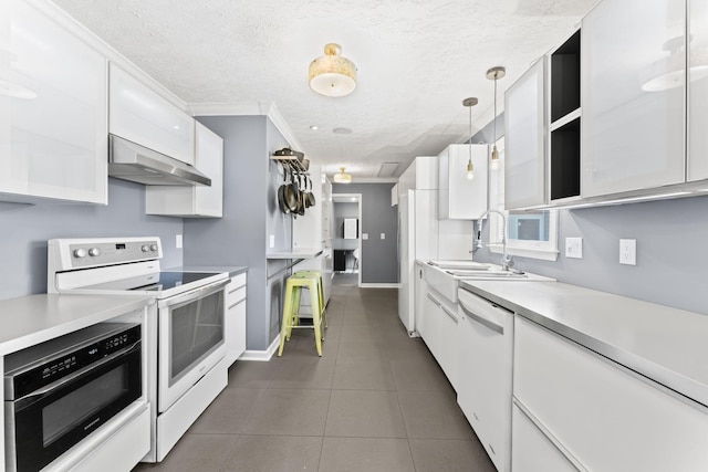 kitchen with under cabinet range hood, white appliances, and white cabinetry