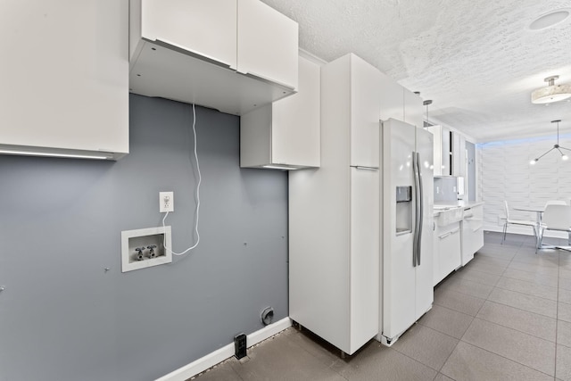 kitchen featuring decorative light fixtures, white cabinets, a textured ceiling, and baseboards