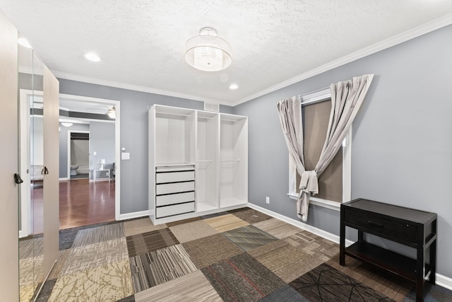 interior space featuring wood finished floors, visible vents, baseboards, a textured ceiling, and crown molding