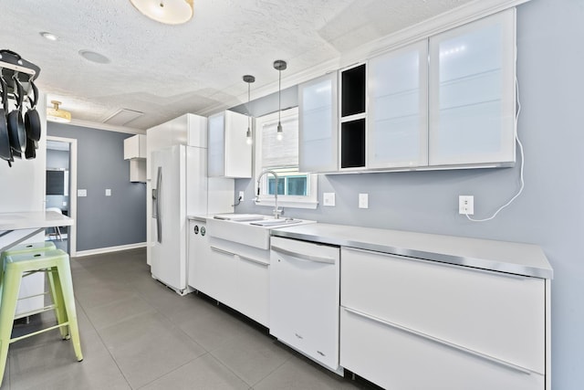 kitchen featuring a sink, white cabinets, light countertops, and white dishwasher