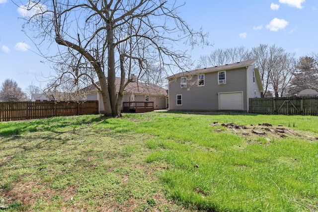 view of yard featuring a garage, a deck, and fence