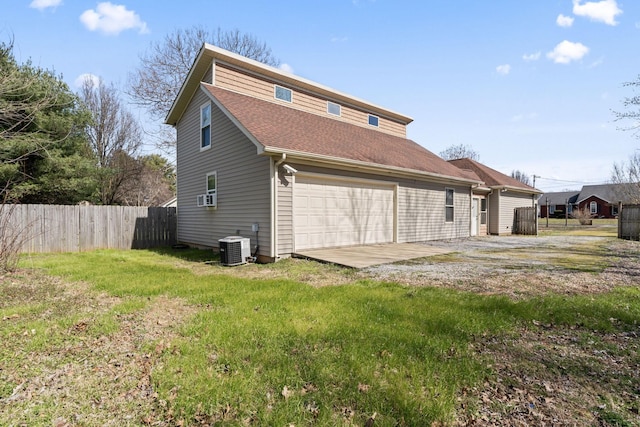 back of house featuring cooling unit, central AC unit, fence, a yard, and a garage