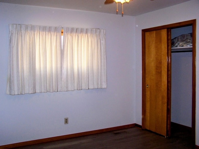 unfurnished bedroom with a closet, ceiling fan, baseboards, and wood finished floors