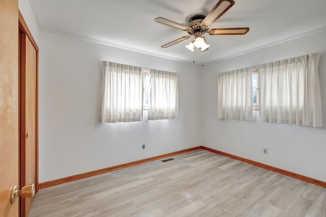 unfurnished room featuring visible vents, baseboards, light wood-style flooring, and a ceiling fan