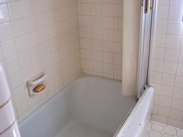 full bathroom featuring tile patterned floors, shower / tub combination, and tile walls