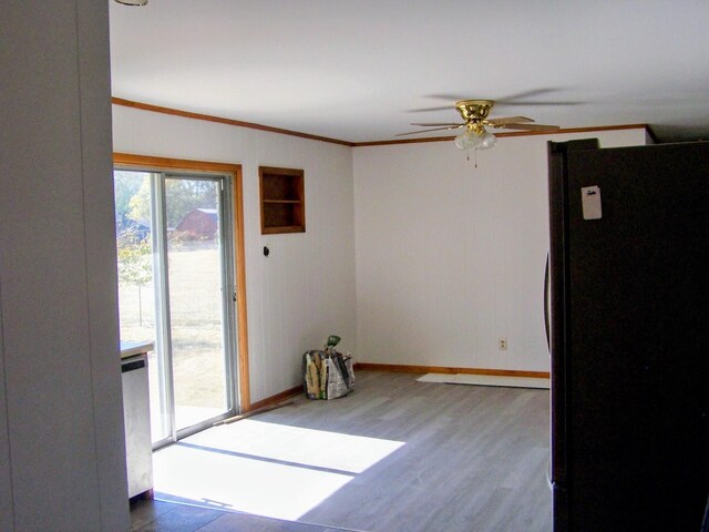 unfurnished room with ceiling fan, crown molding, baseboards, and wood finished floors