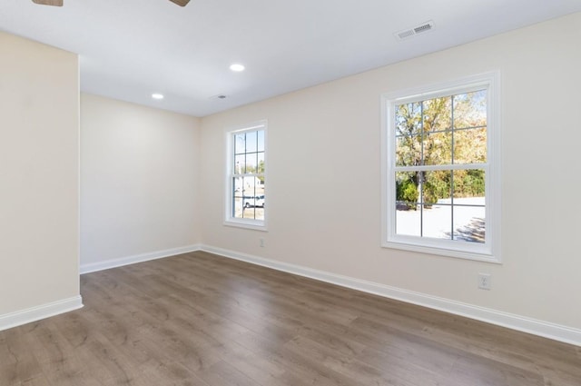 unfurnished room featuring visible vents, recessed lighting, baseboards, and wood finished floors