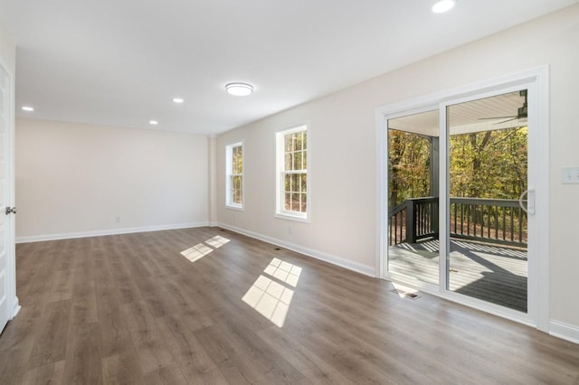 spare room featuring recessed lighting, baseboards, and wood finished floors