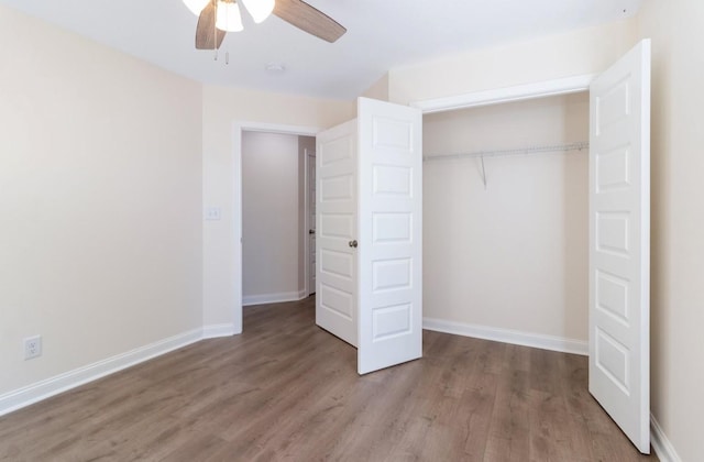 unfurnished bedroom with a closet, baseboards, and wood finished floors