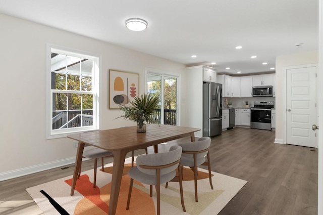 dining area featuring visible vents, recessed lighting, dark wood-type flooring, and baseboards