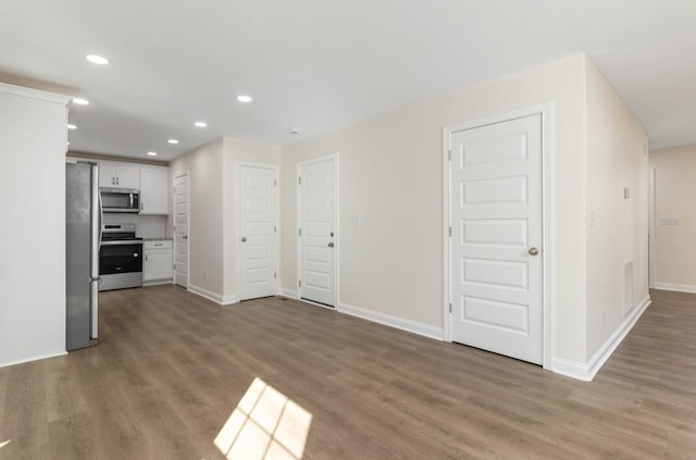 kitchen featuring white cabinetry, light wood finished floors, recessed lighting, and appliances with stainless steel finishes