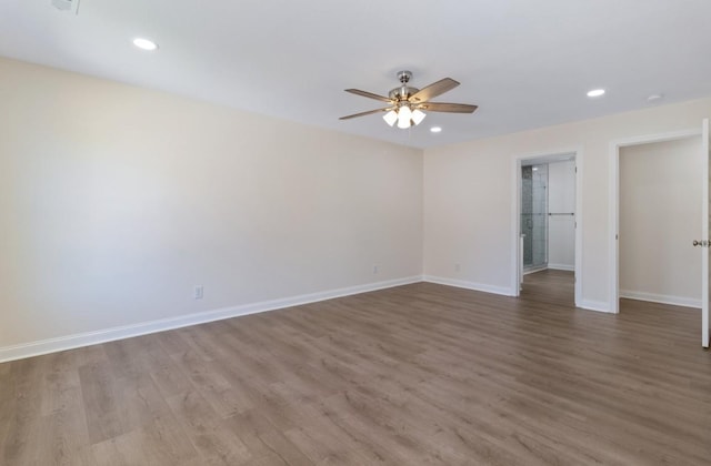 spare room with a ceiling fan, recessed lighting, wood finished floors, and baseboards