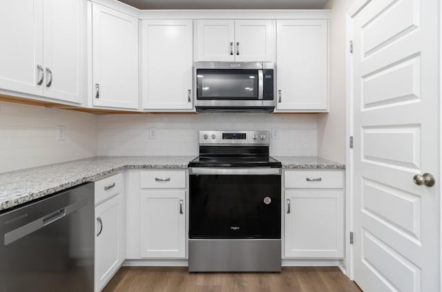 kitchen with dark wood-style floors, backsplash, white cabinetry, and stainless steel appliances