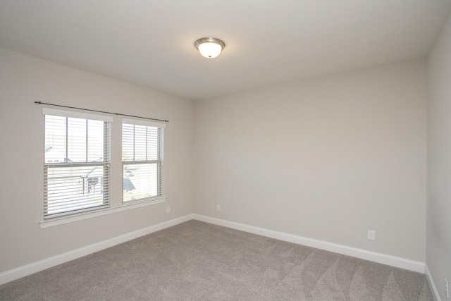 unfurnished room with baseboards and carpet floors