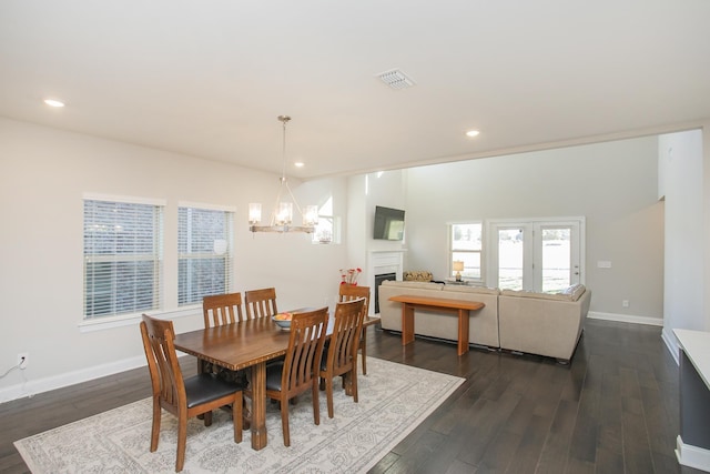 dining space featuring visible vents, a fireplace, dark wood-type flooring, and baseboards