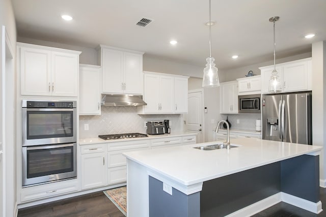 kitchen with visible vents, under cabinet range hood, dark wood finished floors, appliances with stainless steel finishes, and a sink