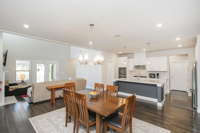 dining room with dark wood finished floors, a notable chandelier, recessed lighting, and visible vents