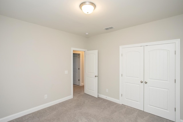 unfurnished bedroom with visible vents, baseboards, a closet, and carpet flooring