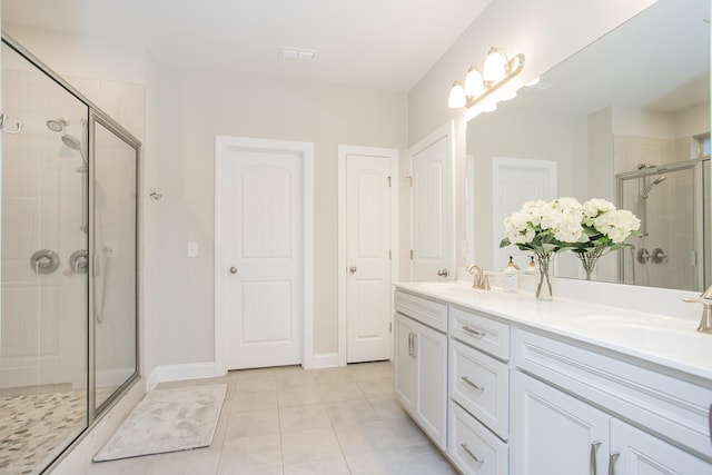 full bathroom featuring double vanity, tile patterned flooring, a shower stall, and a sink