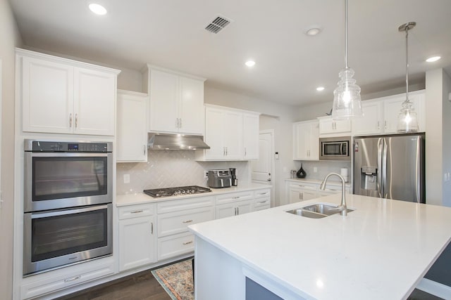 kitchen featuring visible vents, a sink, stainless steel appliances, under cabinet range hood, and tasteful backsplash