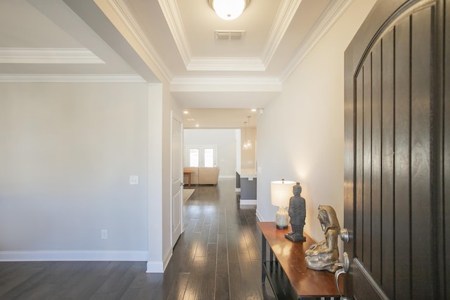 hall featuring visible vents, arched walkways, ornamental molding, dark wood-type flooring, and a raised ceiling