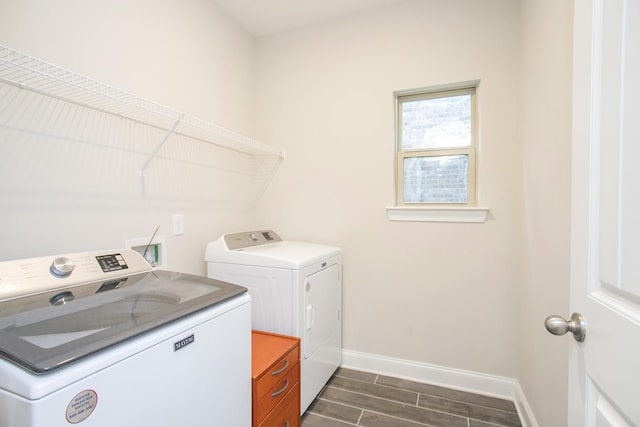 laundry area featuring laundry area, washing machine and dryer, baseboards, and wood tiled floor