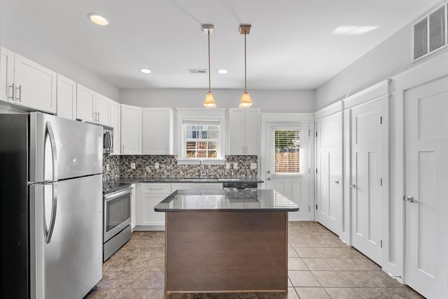 kitchen featuring visible vents, backsplash, a center island, appliances with stainless steel finishes, and white cabinets