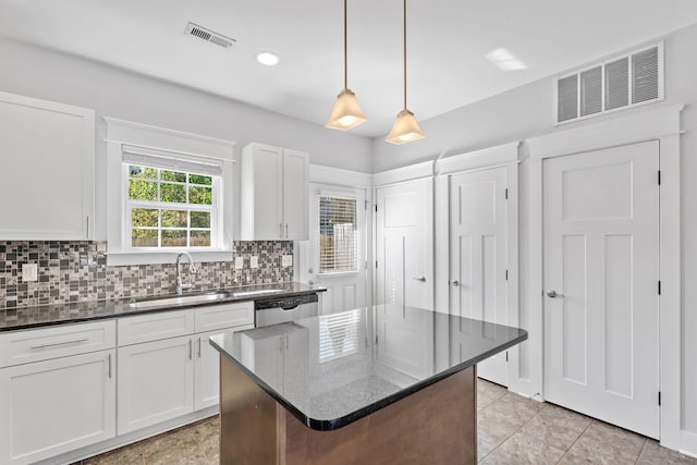 kitchen with visible vents, backsplash, stainless steel dishwasher, and a sink