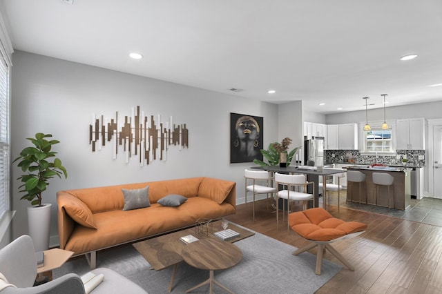 living room with dark wood-style floors, visible vents, recessed lighting, and baseboards