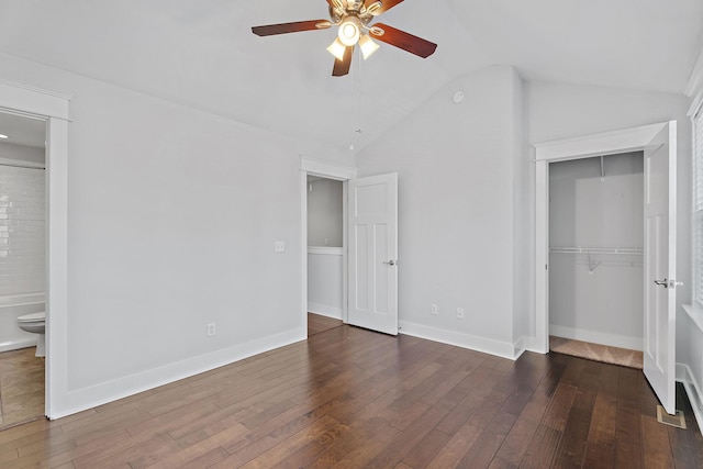 unfurnished bedroom featuring vaulted ceiling, wood finished floors, a closet, and baseboards