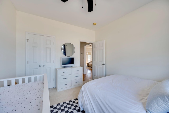 bedroom featuring a closet, light colored carpet, and ceiling fan