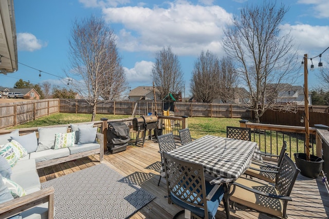 wooden deck featuring a lawn, an outdoor hangout area, outdoor dining area, and a fenced backyard