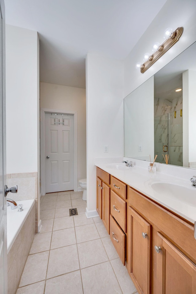 bathroom featuring double vanity, toilet, a marble finish shower, and a sink