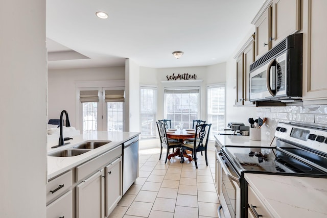 kitchen featuring light tile patterned floors, recessed lighting, a sink, decorative backsplash, and appliances with stainless steel finishes