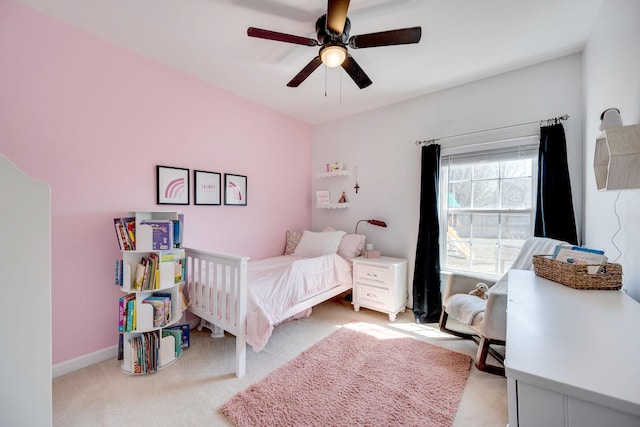 bedroom featuring light colored carpet, baseboards, and ceiling fan