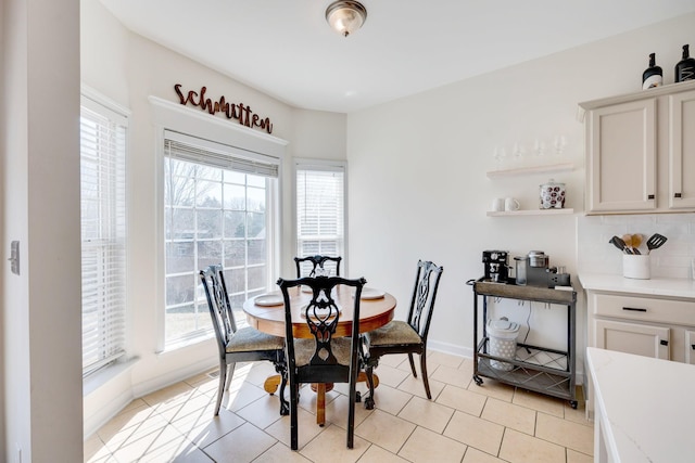 dining room with light tile patterned floors, baseboards, and a healthy amount of sunlight