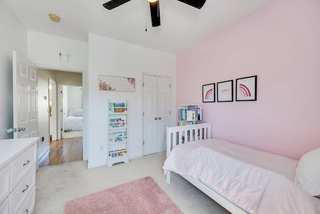 bedroom with a closet, light colored carpet, and a ceiling fan