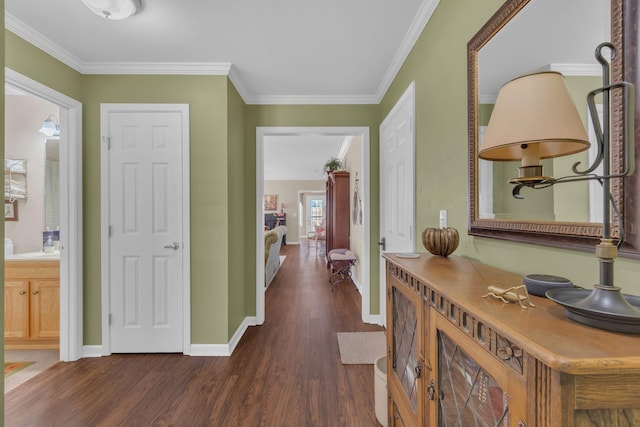 hall featuring dark wood-style floors, crown molding, and baseboards