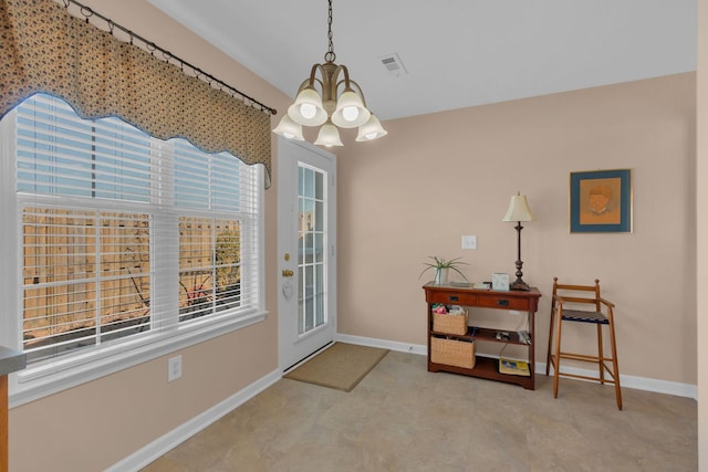 doorway featuring a notable chandelier, visible vents, and baseboards