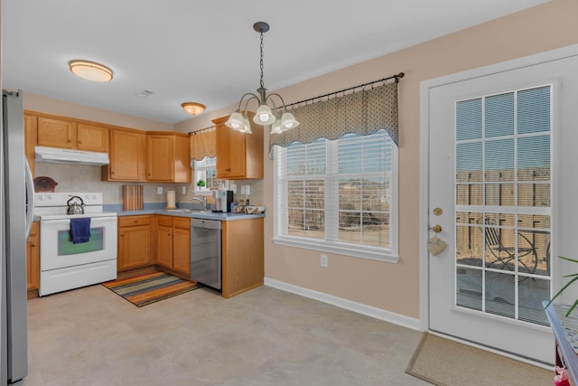 kitchen with under cabinet range hood, stainless steel appliances, hanging light fixtures, and light countertops