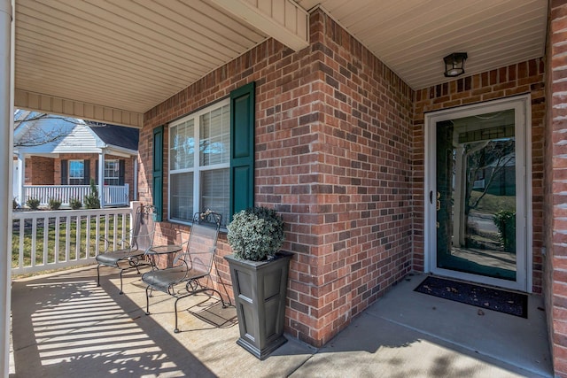 entrance to property with brick siding and covered porch