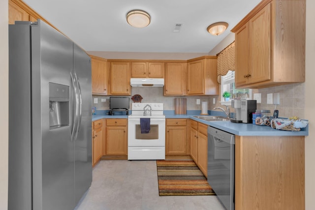 kitchen with under cabinet range hood, a sink, appliances with stainless steel finishes, light countertops, and decorative backsplash