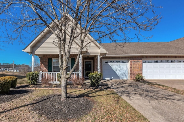 view of front of property featuring brick siding, covered porch, concrete driveway, and a garage