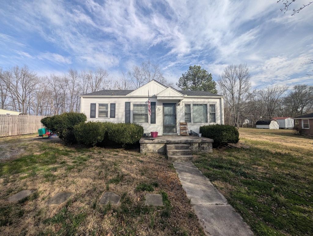 bungalow-style house featuring board and batten siding, a front yard, and fence