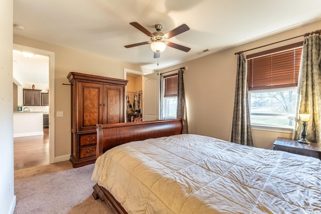 carpeted bedroom featuring visible vents, baseboards, and ceiling fan